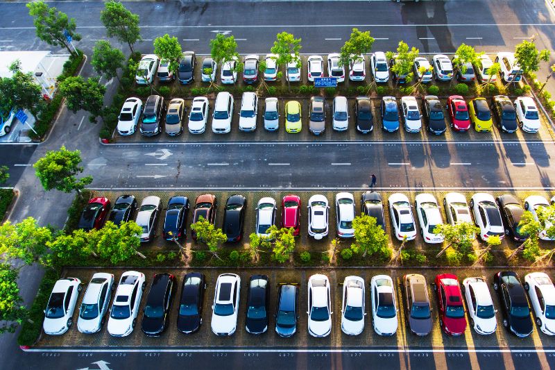 Aerial view of a large tree lined full car park